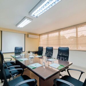 Salón VIP para reuniones y eventos corporativos en Hotel Arizona Suites Cúcuta, con mesa ejecutiva y equipamiento moderno.